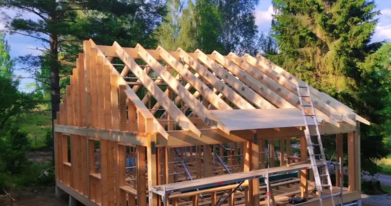 En husstomme i trä som byggs i skogen.